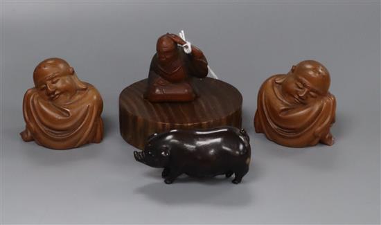 A 19th century Japanese wood netsuke of a seated man together with three carved wood figures 4cm - 6cm